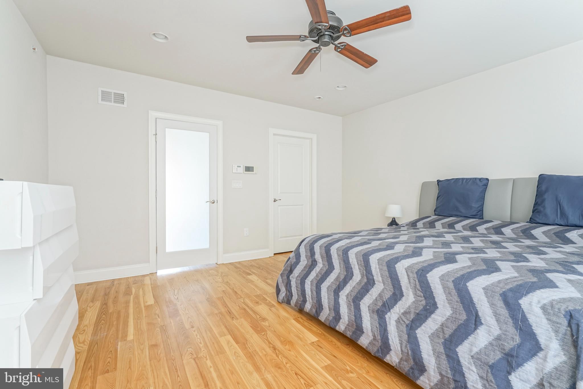 2332 Ellsworth Street Philadelphia, PA 19146 - Photo 22 of 29 a bedroom with a bed and wooden floor