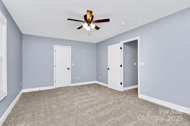 a view of an empty room with a ceiling fan
