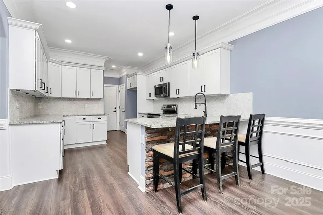 a kitchen with stainless steel appliances granite countertop a stove a sink and a refrigerator