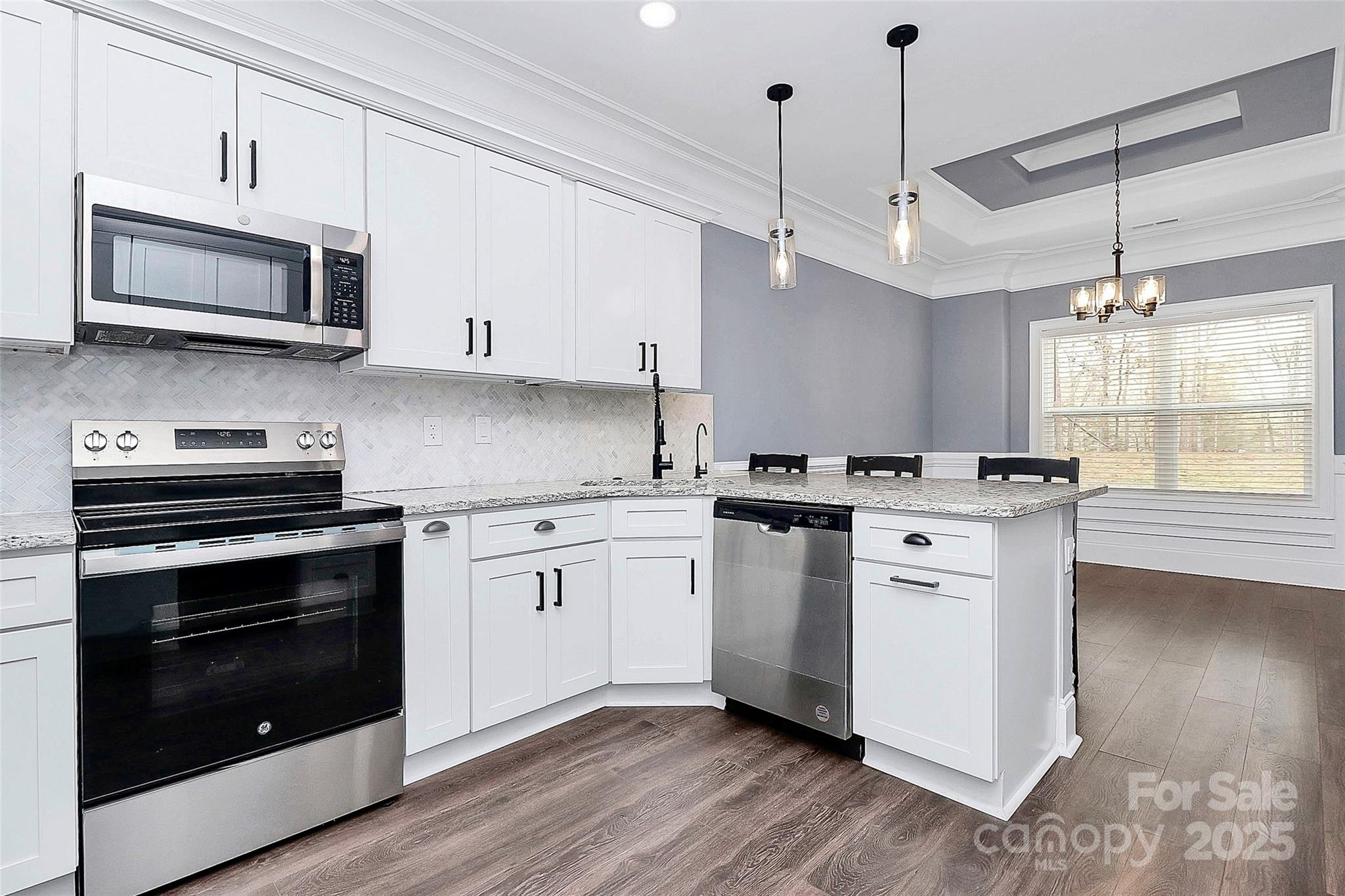 6519 Pargo Road Charlotte, NC 28216 - Photo 31 of 37 a kitchen with kitchen island granite countertop a sink cabinets and stainless steel appliances