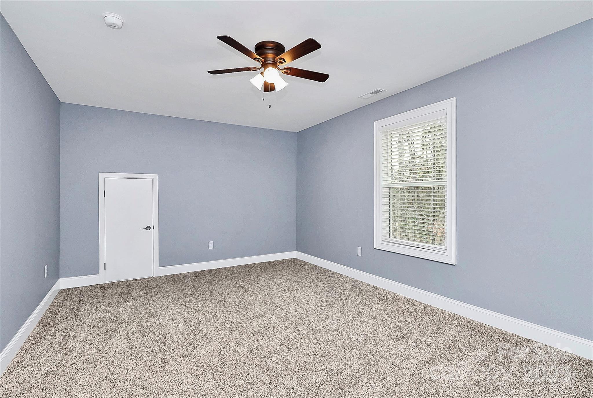 6519 Pargo Road Charlotte, NC 28216 - Photo 10 of 37 an empty room with chandelier fan and windows