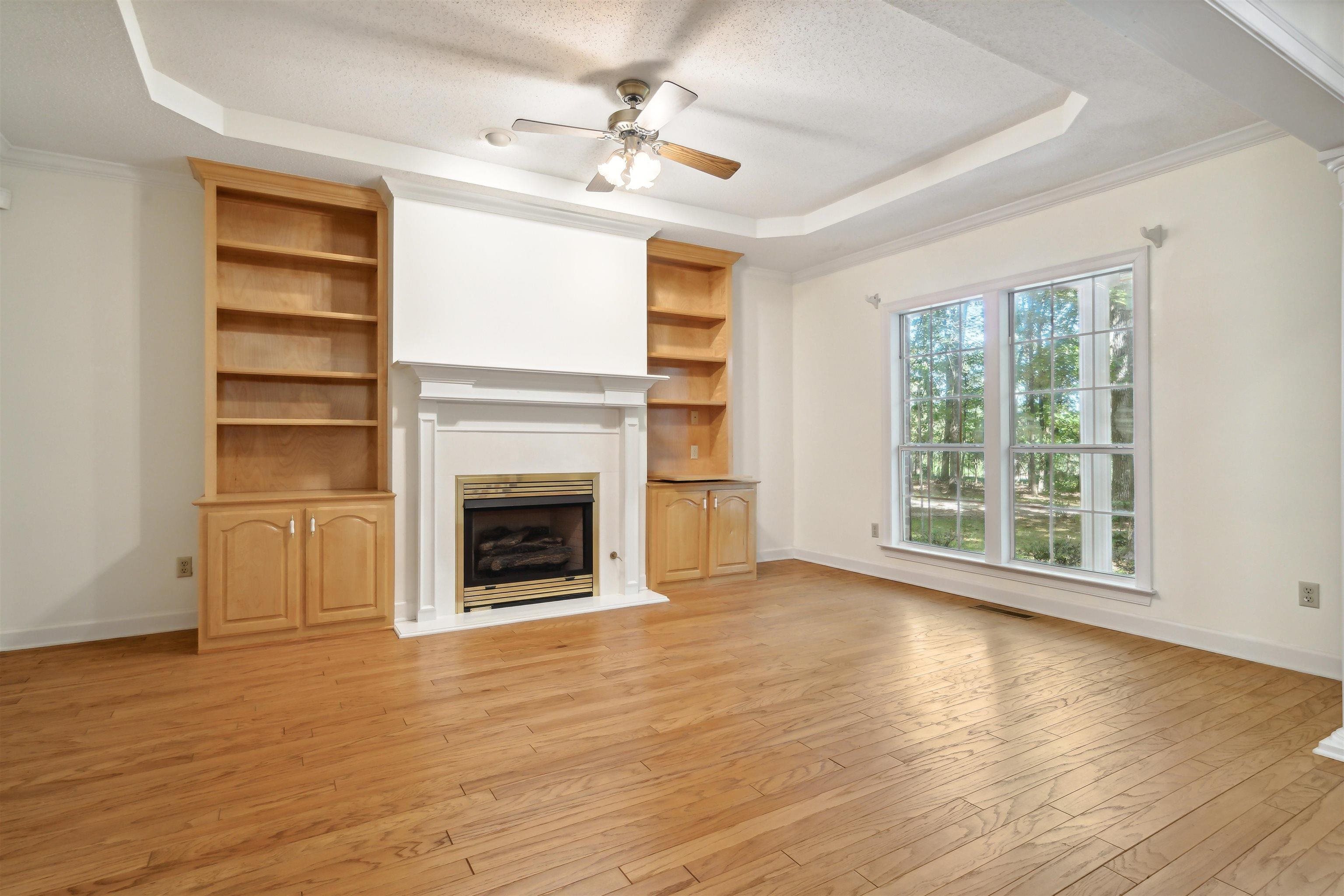 3255 Highway 196 Piperton, TN 38017 - Photo 9 of 22 a view of a livingroom with a fireplace a ceiling fan and wooden floor