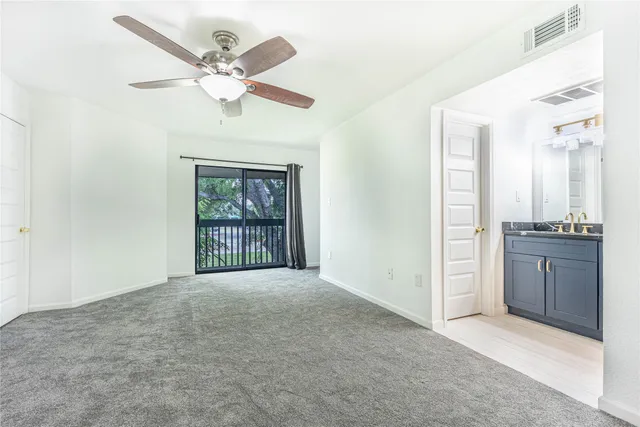 an empty room with a window and a ceiling fan