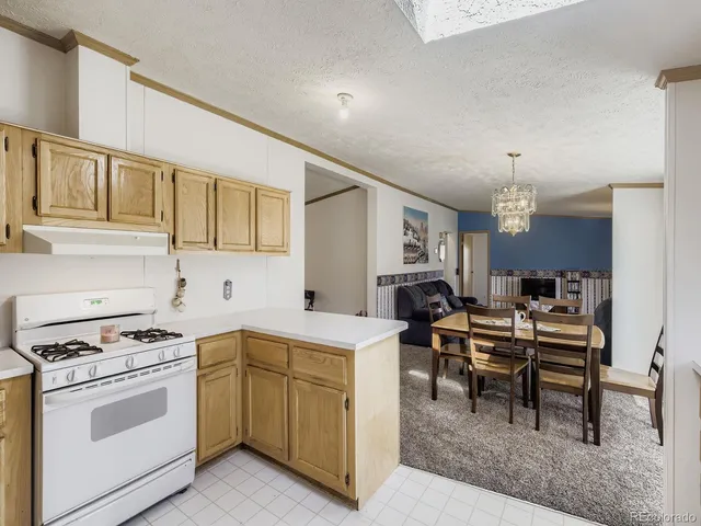 a kitchen with a stove a sink a dining table and chairs