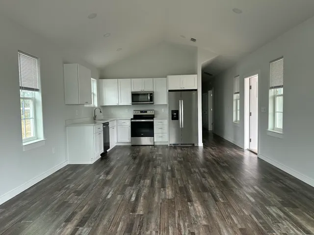 a view of kitchen with wooden floor electronic appliances and window