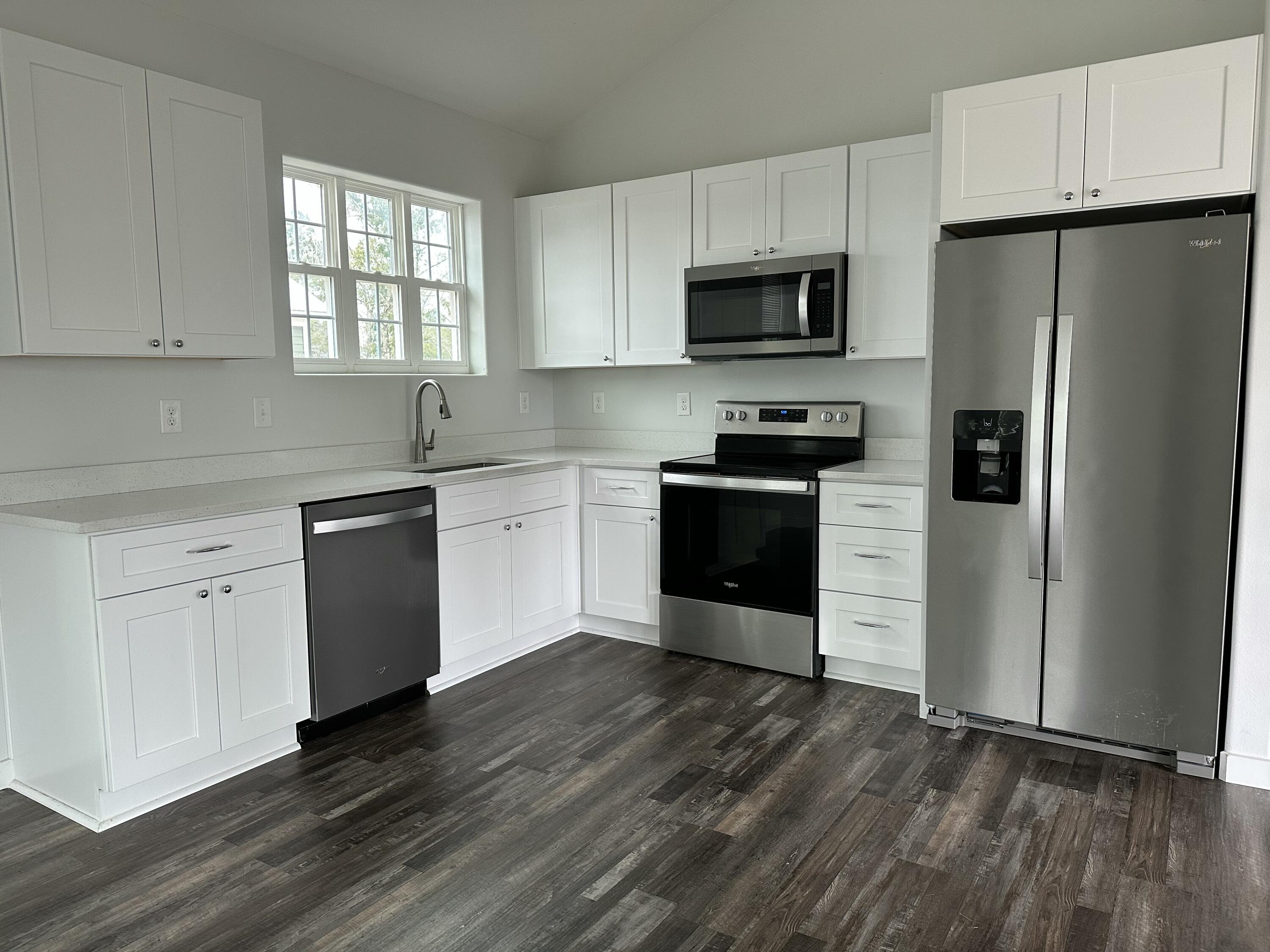524 North Raphael Road DeFuniak Springs, FL 32433 - Photo 5 of 15 a kitchen with granite countertop a refrigerator stove a sink and dishwasher with wooden floor