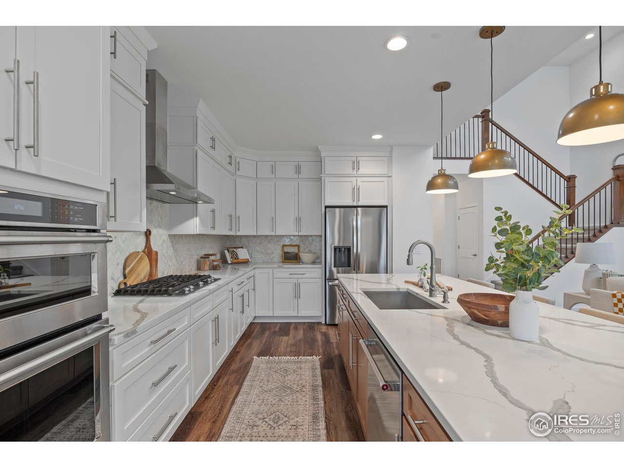 5070 Kidd Street Timnath, CO 80547 - Photo 15 of 42 a kitchen with granite countertop a sink stainless steel appliances and cabinets