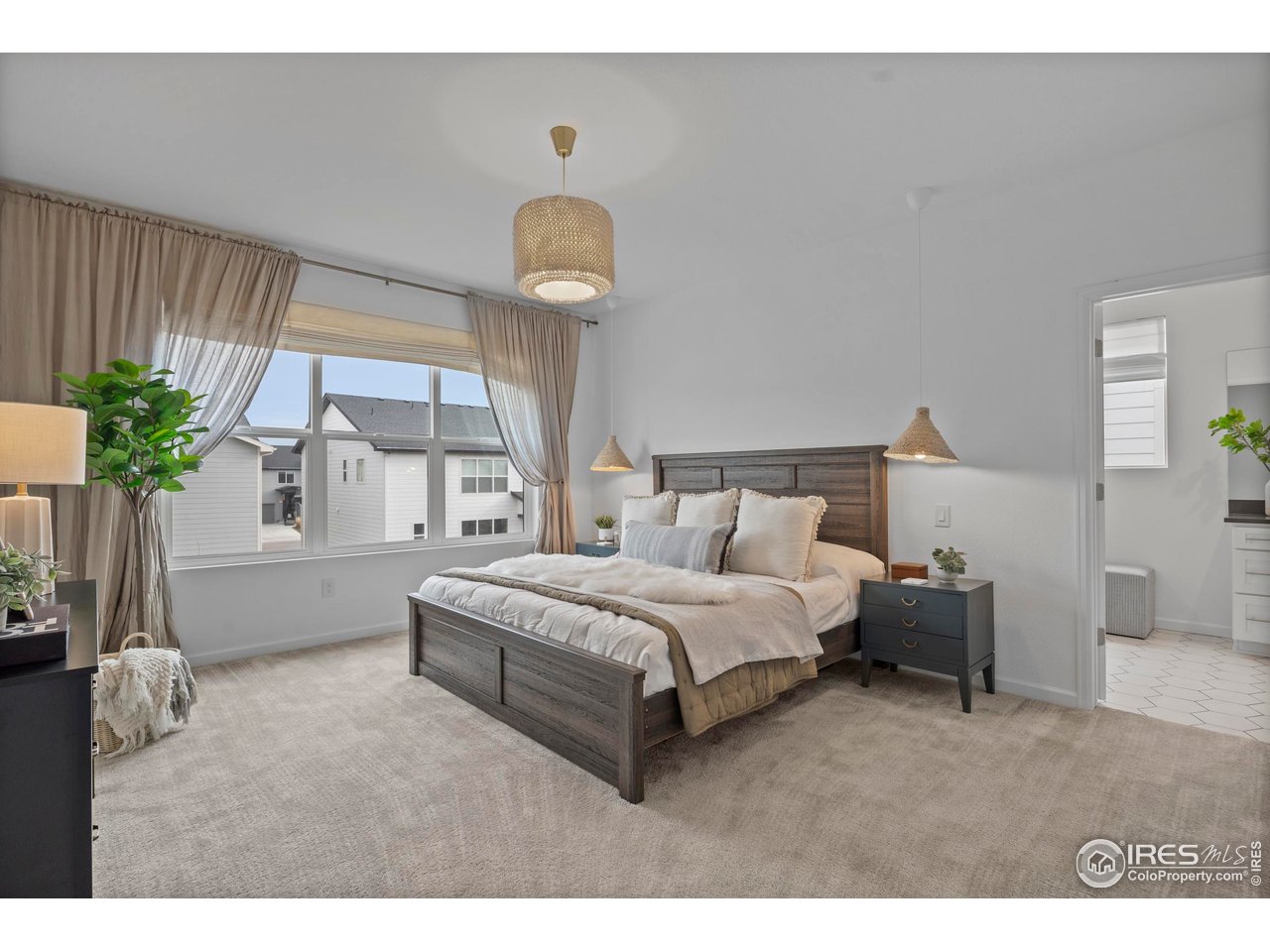 5070 Kidd Street Timnath, CO 80547 - Photo 22 of 42 a spacious bedroom with a bed and a chandelier