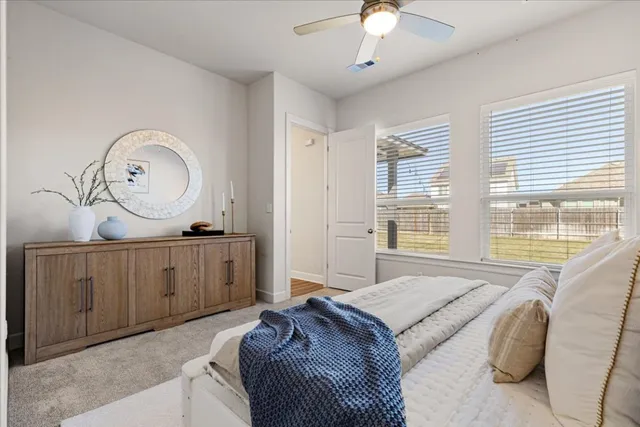 a spacious bedroom with a large bed and a chandelier