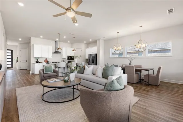 a living room with furniture kitchen view and a chandelier
