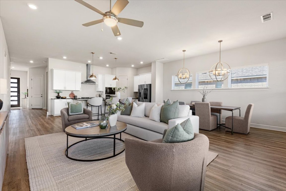908 Knowles Drive Hutto, TX 78634 - Photo 16 of 37 a living room with furniture kitchen view and a chandelier