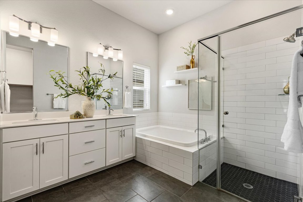 908 Knowles Drive Hutto, TX 78634 - Photo 18 of 37 a bathroom with a tub sink and mirror