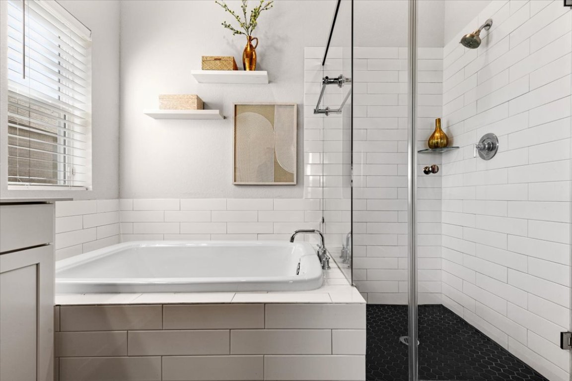 908 Knowles Drive Hutto, TX 78634 - Photo 19 of 37 a bathroom with a bathtub and a shower