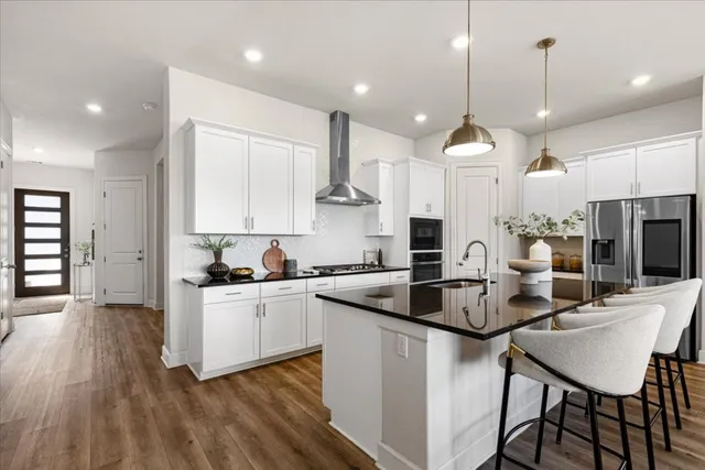 a kitchen with kitchen island a stove a table and chairs in it