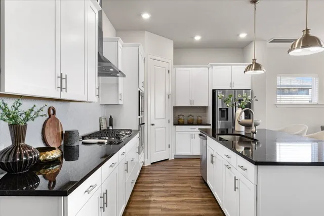 a large kitchen with stainless steel appliances granite countertop a stove a sink and a refrigerator