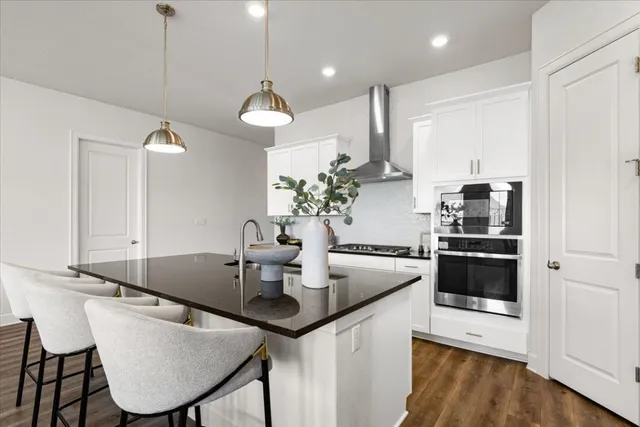 a kitchen with kitchen island granite countertop a sink a counter space appliances and cabinets