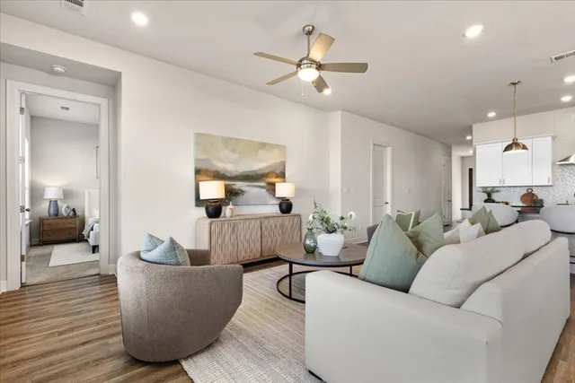 a living room with furniture and a wooden floor