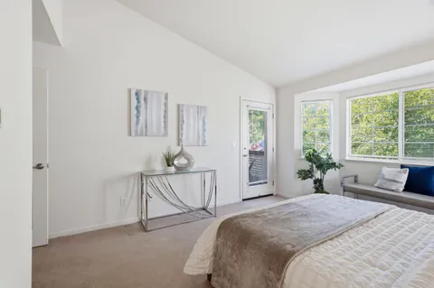 a spacious bedroom with a bed and a large window