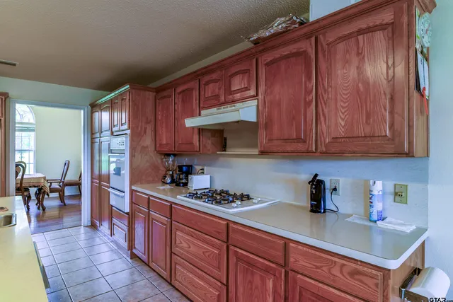 a kitchen with stainless steel appliances granite countertop wooden cabinets a sink and dishwasher