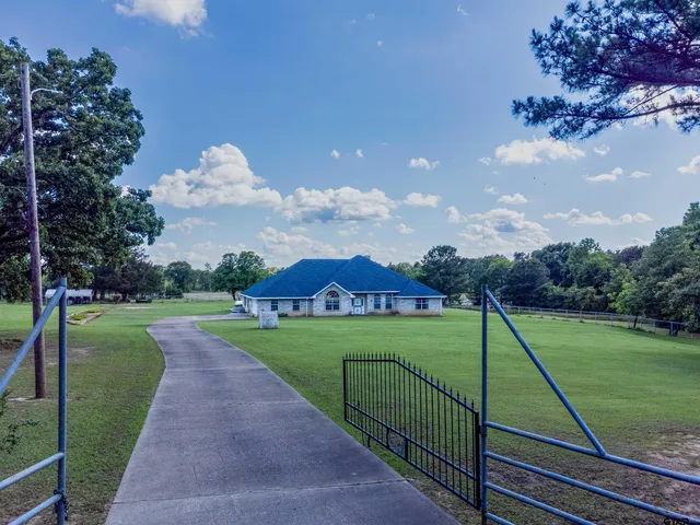 a backyard of a house with lots of green space and outdoor seating