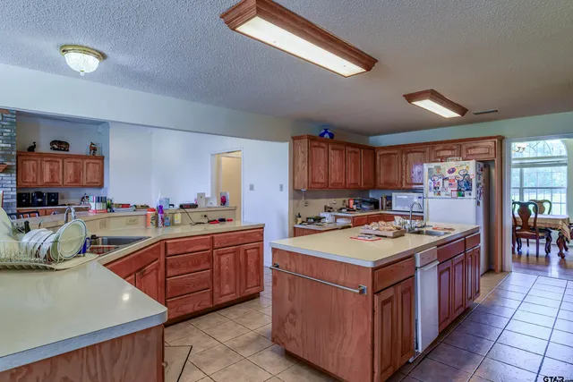 a kitchen with stainless steel appliances granite countertop a stove a sink dishwasher and a refrigerator