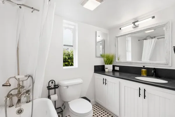 a bathroom with a granite countertop sink a toilet and mirror