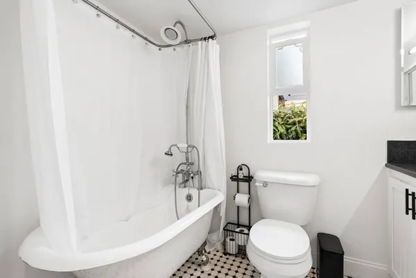 a white toilet sitting next to a white tub