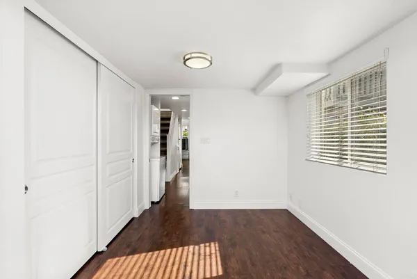 a view of a hallway with wooden floor and a window