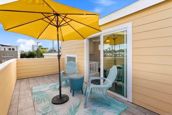 a view of a street with chairs under an umbrella