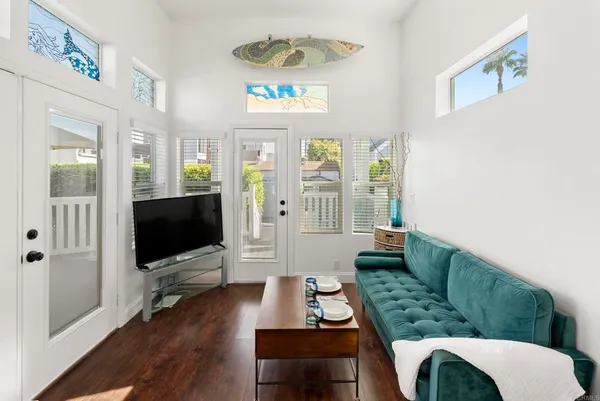 a living room with furniture a flat screen tv and a window