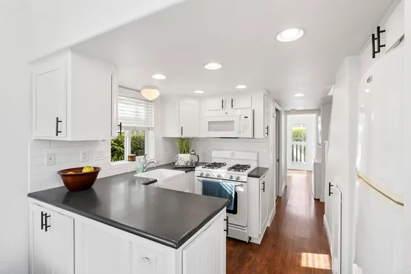 a kitchen with stainless steel appliances granite countertop a sink a stove and a refrigerator