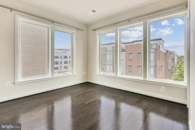 an empty room with wooden floor and a bathroom