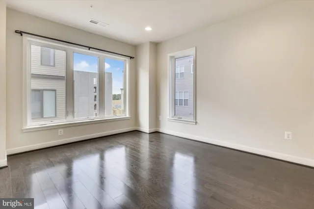 an empty room with wooden floor and closet area