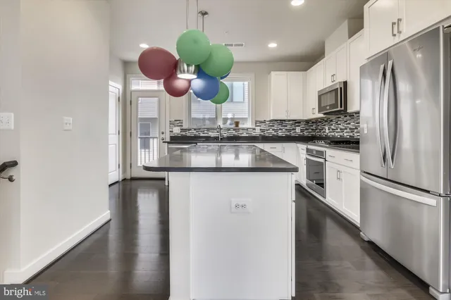 a kitchen with stainless steel appliances granite countertop a sink a refrigerator and a granite counter tops