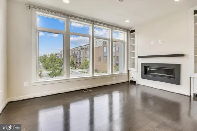 a view of an empty room with a window and a fireplace
