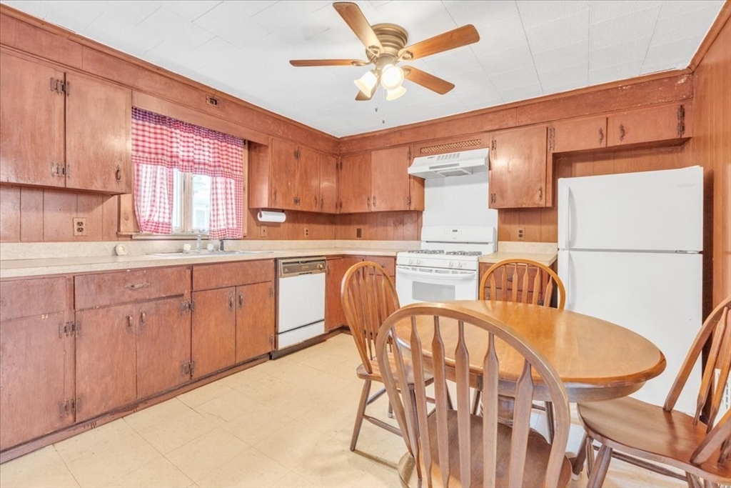 4 Springer Street Boston, MA 02127 - Photo 5 of 18 a kitchen with stainless steel appliances granite countertop a dining table chairs refrigerator a sink and dishwasher