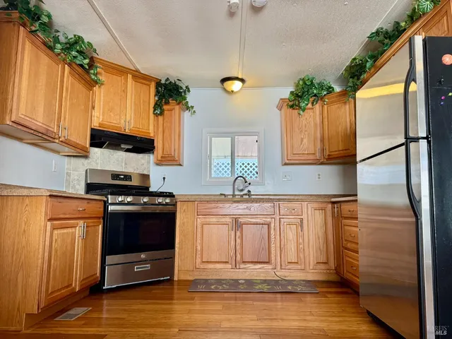a kitchen with stainless steel appliances granite countertop a refrigerator stove and sink