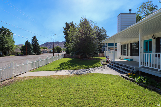 270 East 100 North Monroe, UT 84754 - Photo 3 of 65 Front exterior featuring a white picket fence, covered porch, and vibrant turquoise entry door