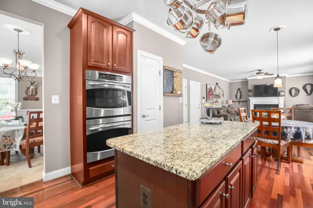 a kitchen with stainless steel appliances granite countertop a sink dishwasher stove and refrigerator with wooden floor