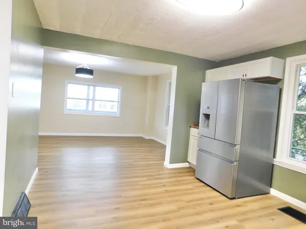 a view of a kitchen with wooden floor and electronic appliances