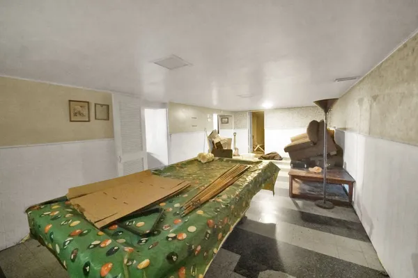 a bed sitting in a spacious bedroom next to a window