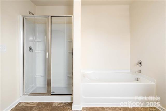 9740 Weikert Road Charlotte, NC 28215 - Photo 10 of 16 a bathroom with a bathtub and a shower