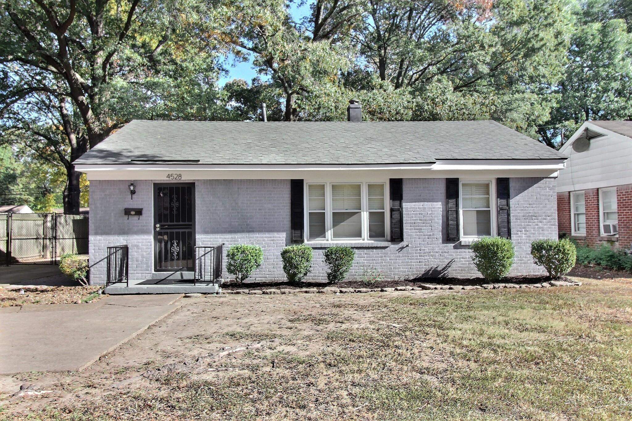 4528 Quince Road Memphis, TN 38117 - Photo 1 of 27 a front view of a house with a garden