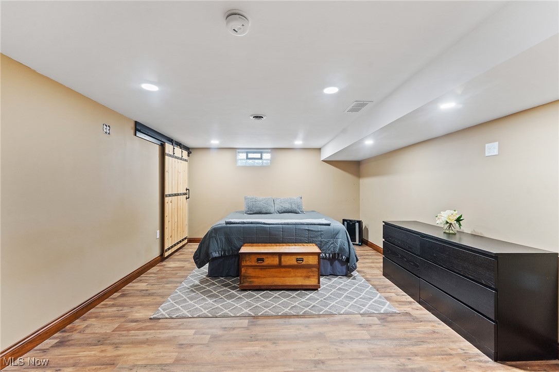 6152 Chestnut-Ridge Road Hubbard, OH 44425 - Photo 22 of 28 Bedroom with a barn door and light hardwood / wood-style floors
