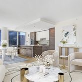 a living room with furniture and a dining table with kitchen view