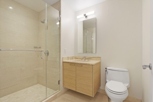 a bathroom with a granite countertop sink toilet and shower