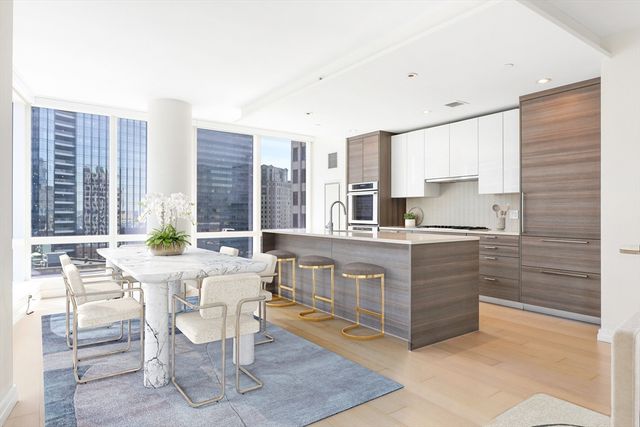 a living room with stainless steel appliances kitchen island granite countertop a table and chairs