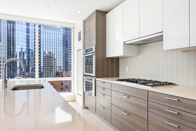 a kitchen with granite countertop a sink stove and cabinets
