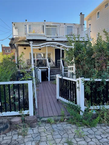 a view of a house with wooden deck and furniture