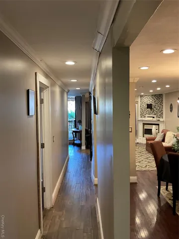 a view of a hallway with wooden floor kitchen and a sink